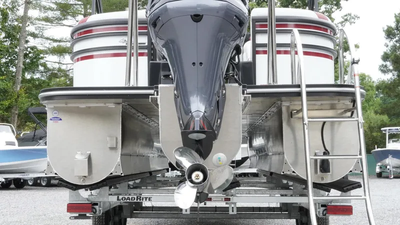 Slide: The Image of 2025 SunCatcher Select 322RC pontoon boat on trailer, rear view with motor and ladder. - 5
