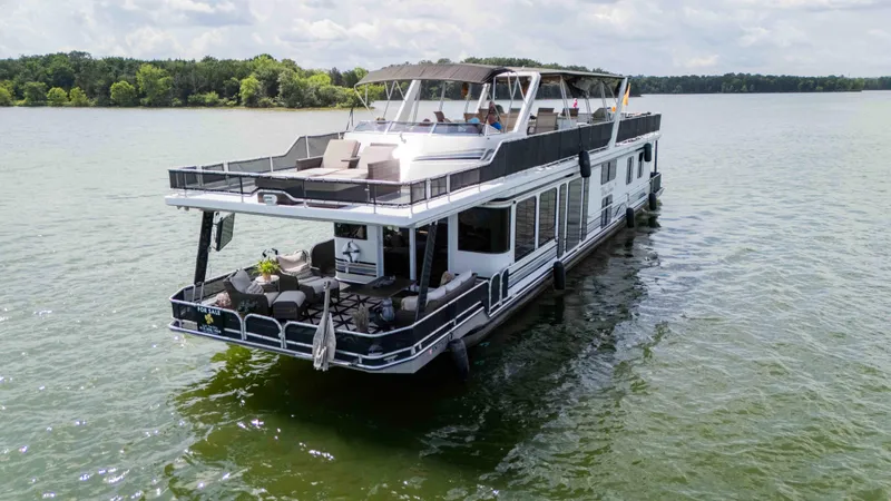 Slide: The Image of 1998 Sumerset houseboat on a lake, featuring spacious decks and modern amenities. - 11