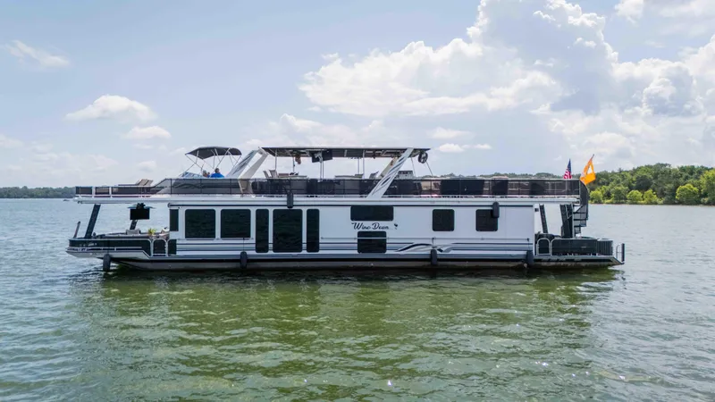Slide: The Image of 1998 Sumerset houseboat on a serene lake under a partly cloudy sky. - 14