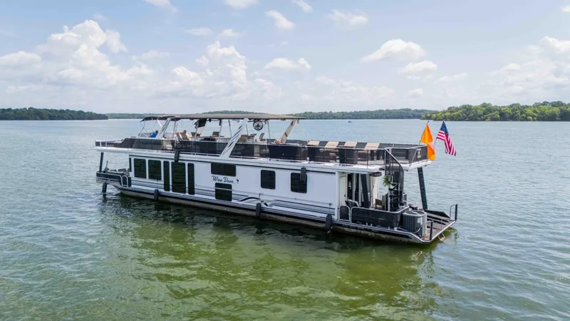Slide: The Image of 1998 Sumerset houseboat on a serene lake under a partly cloudy sky. - 15