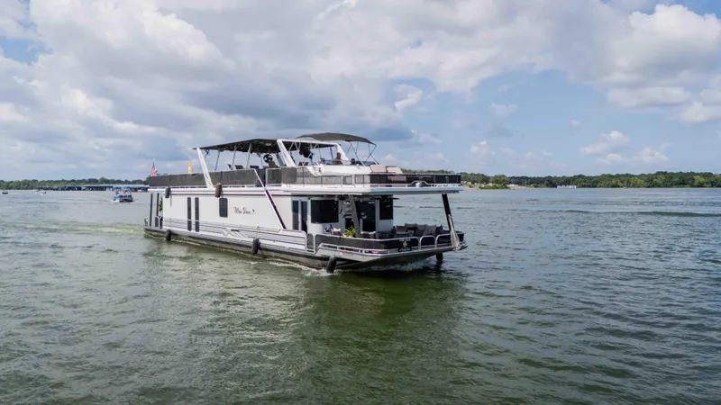 Slide: The Image of 1998 Sumerset houseboat cruising on a lake under a partly cloudy sky. - 2