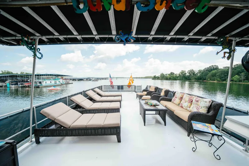 Slide: The Image of 1998 Sumerset houseboat deck with lounge chairs and scenic lake view. - 24