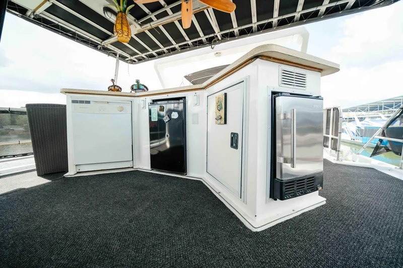 Slide: The Image of 1998 Sumerset houseboat kitchen area with appliances and outdoor seating. - 27