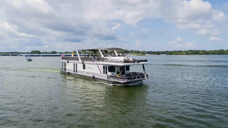 Slide: The Image of 1998 Sumerset houseboat cruising on a lake under a partly cloudy sky. - 3