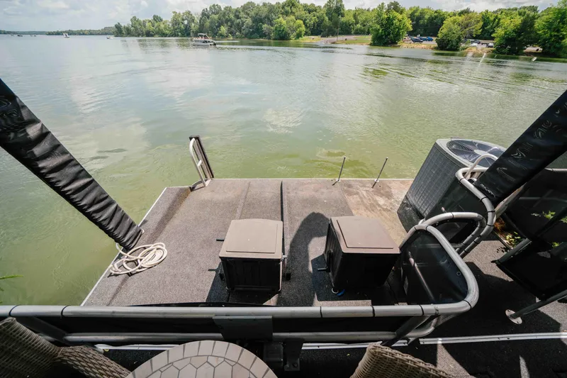 Slide: The Image of 1998 Sumerset houseboat deck overlooking serene lake with lush green shoreline. - 32
