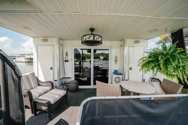 Slide: The Image of 1998 Sumerset houseboat deck with seating, table, and lush greenery. - 33