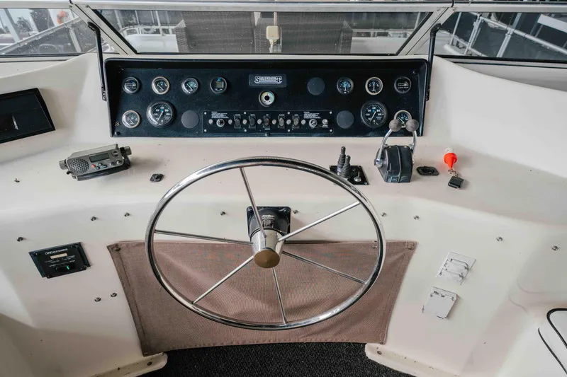 Slide: The Image of 1998 Sumerset Houseboat helm with steering wheel and control panel. - 34