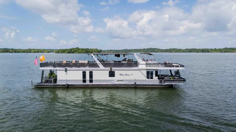 Slide: The Image of 1998 Sumerset houseboat on a lake under a partly cloudy sky. - 4