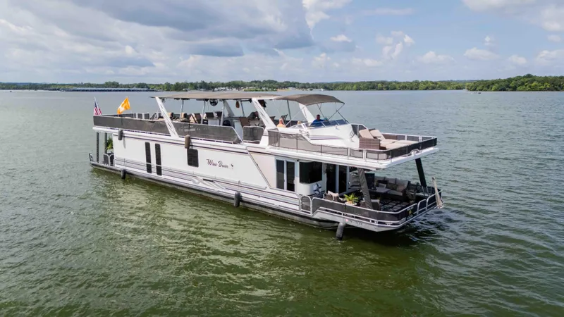 Slide: The Image of 1998 Sumerset houseboat on a lake, featuring spacious decks and modern amenities. - 8