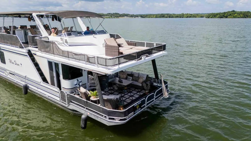 Slide: The Image of 1998 Sumerset houseboat on a lake, featuring spacious decks and modern amenities. - 9