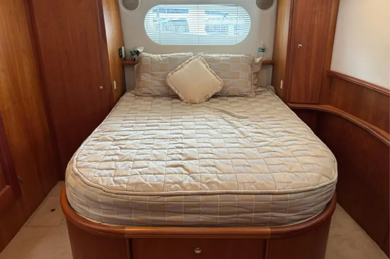 Slide: The Image of Cozy bedroom in 2002 Silverton 43 Motor Yacht with quilted bedding and wooden accents. - 13