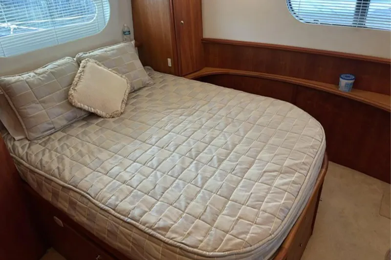 Slide: The Image of Cozy bedroom in 2002 Silverton 43 Motor Yacht with quilted bedding and wooden accents. - 14
