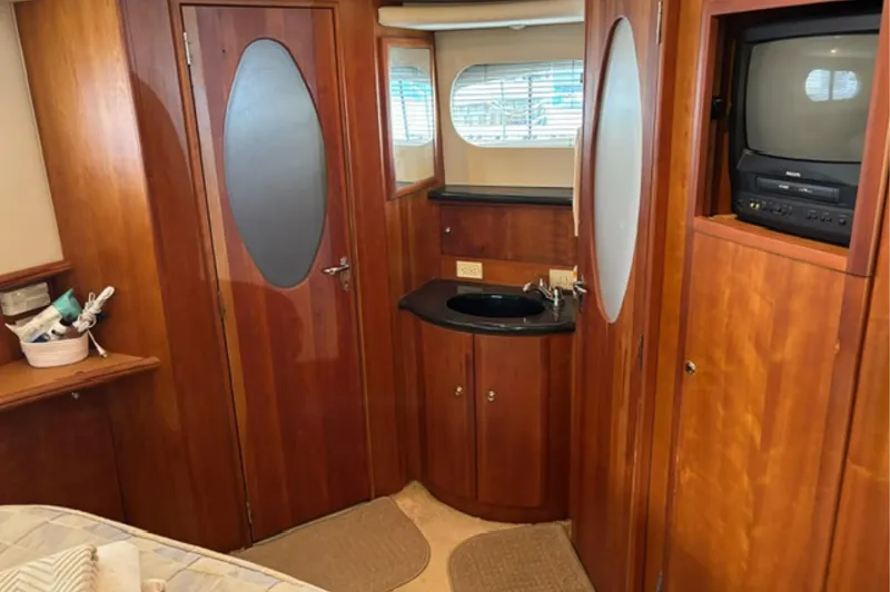 Slide: The Image of Interior of 2002 Silverton 43 Motor Yacht with wood paneling and built-in TV. - 15