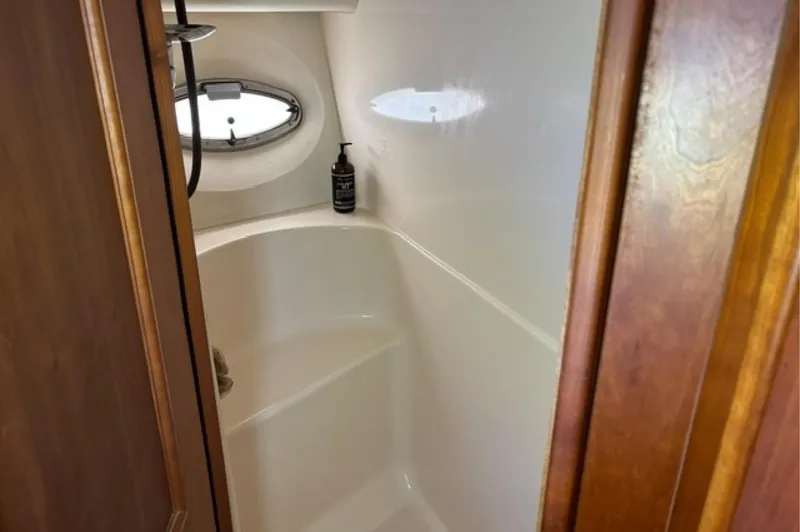 Slide: The Image of Bathroom interior of 2002 Silverton 43 Motor Yacht with porthole and wooden door. - 17