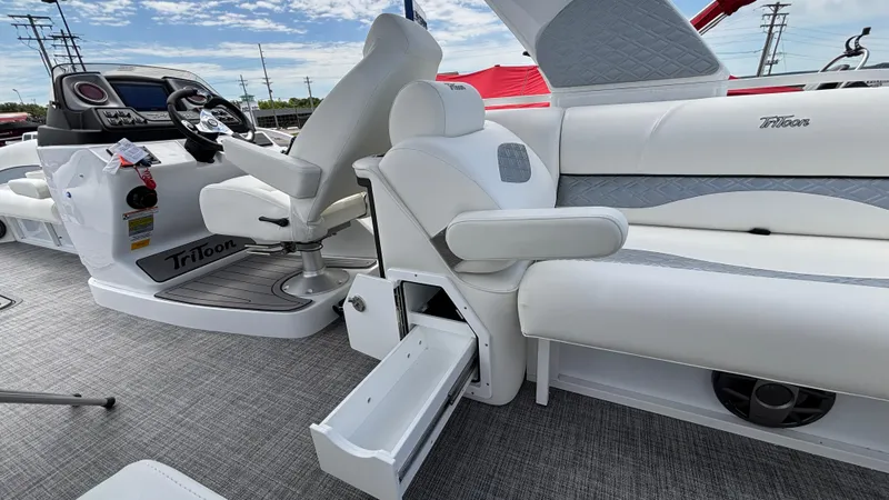 Slide: The Image of 2025 JC Sporttoon 27TT boat interior with white seating and storage drawer. - 19