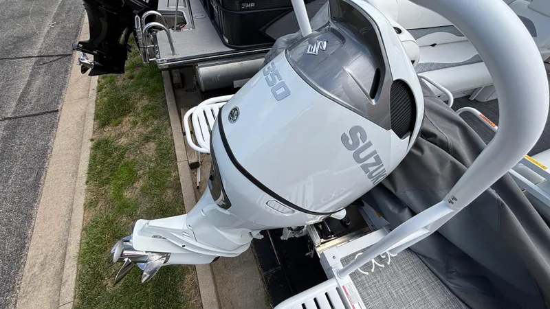 Slide: The Image of 2025 JC Sporttoon 27TT with Suzuki outboard motor, docked on a sunny day. - 21