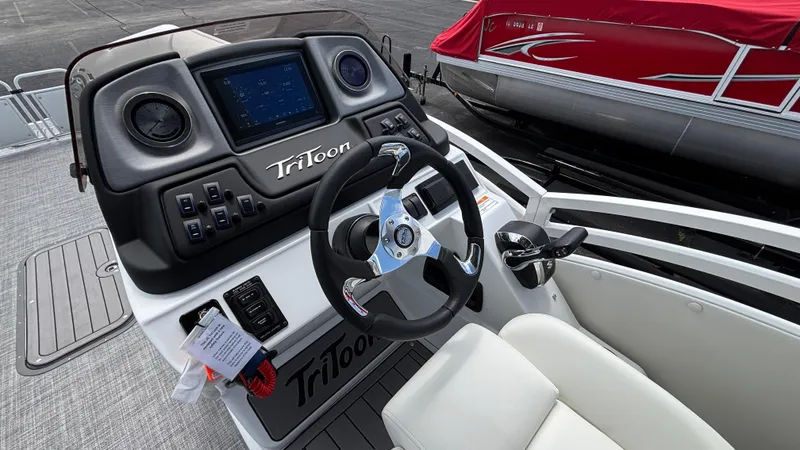 Slide: The Image of 2025 JC Sporttoon 27TT boat dashboard with steering wheel and control panel. - 22