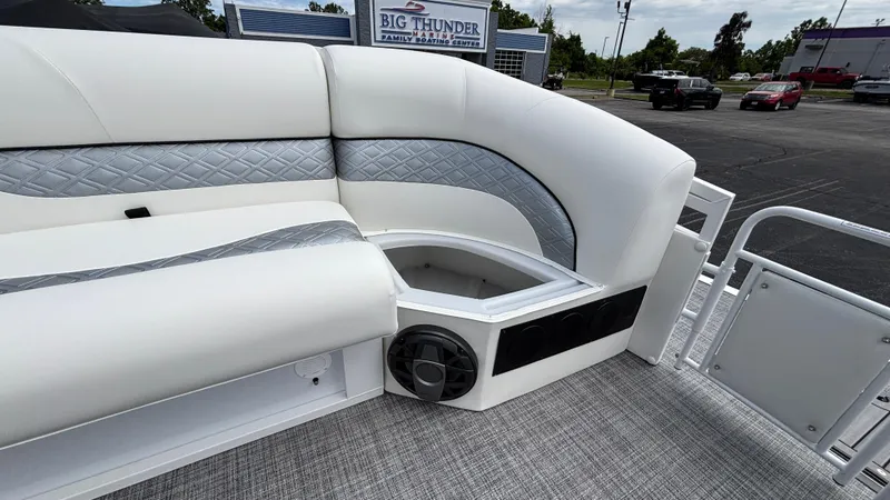 Slide: The Image of 2025 JC Sporttoon 27TT boat interior with white seating and speaker. - 27