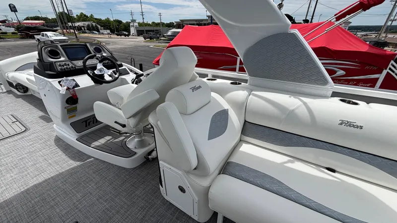 Slide: The Image of 2025 JC Sporttoon 27TT boat interior with plush seating and modern dashboard. - 6