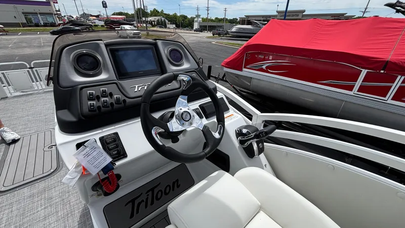 Slide: The Image of 2025 JC Sporttoon 27TT boat dashboard with steering wheel and controls. - 7