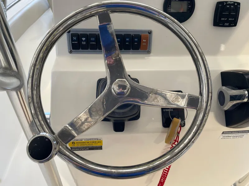 Slide: The Image of Control panel of 2023 Key West 203 FS boat with throttle and cup holders. - 30