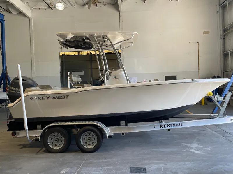 Slide: The Image of 2023 Key West 203 FS boat on trailer in warehouse, featuring Yamaha outboard motor. - 5