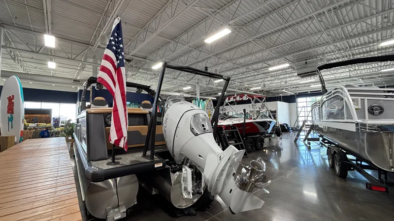 Slide: The Image of Pontoon boat Viaggio Diamante D24UW A-T 2025 in showroom with American flag and outboard motor. - 3