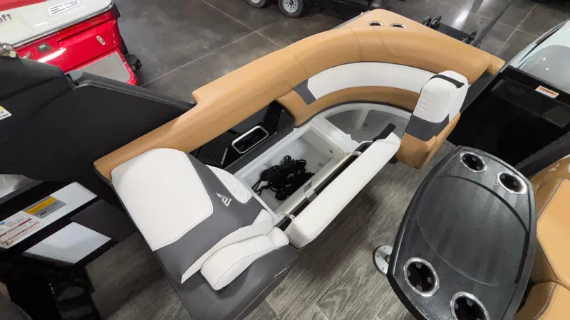 Slide: The Image of 2025 Viaggio Diamante D24UW A-T boat interior with tan and white seating, storage compartment, and cup holders. - 39