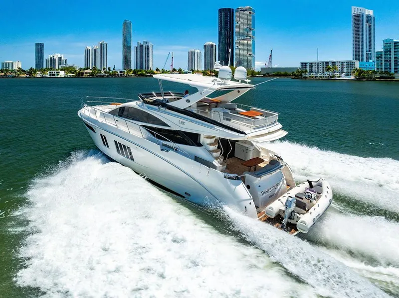 Slide: The Image of 2016 Sea Ray L650 Fly yacht cruising in a city harbor with skyscrapers in the background. - 2