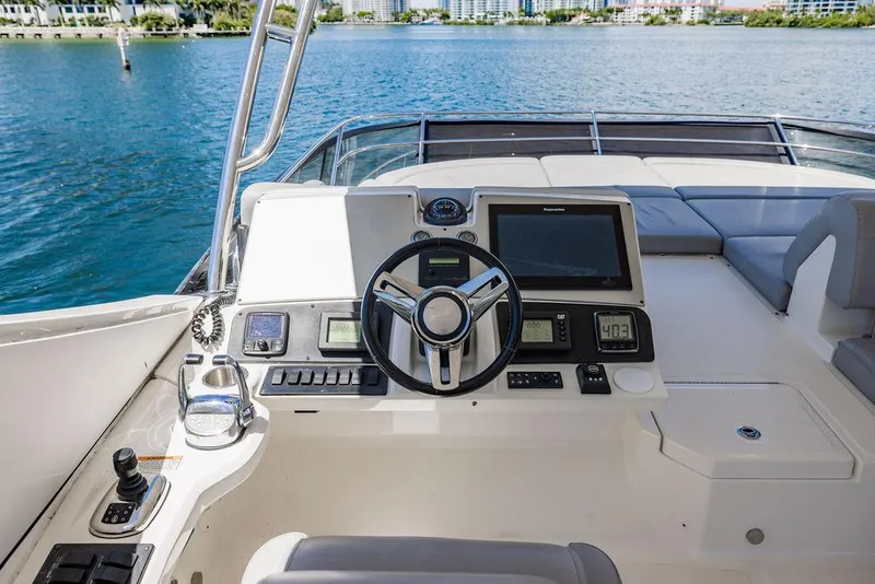 Slide: The Image of 2016 Sea Ray L650 Fly yacht helm with modern navigation equipment and waterfront view. - 25
