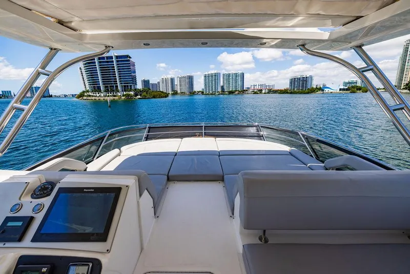 Slide: The Image of 2016 Sea Ray L650 Fly yacht with city skyline view, featuring luxurious deck and navigation controls. - 28