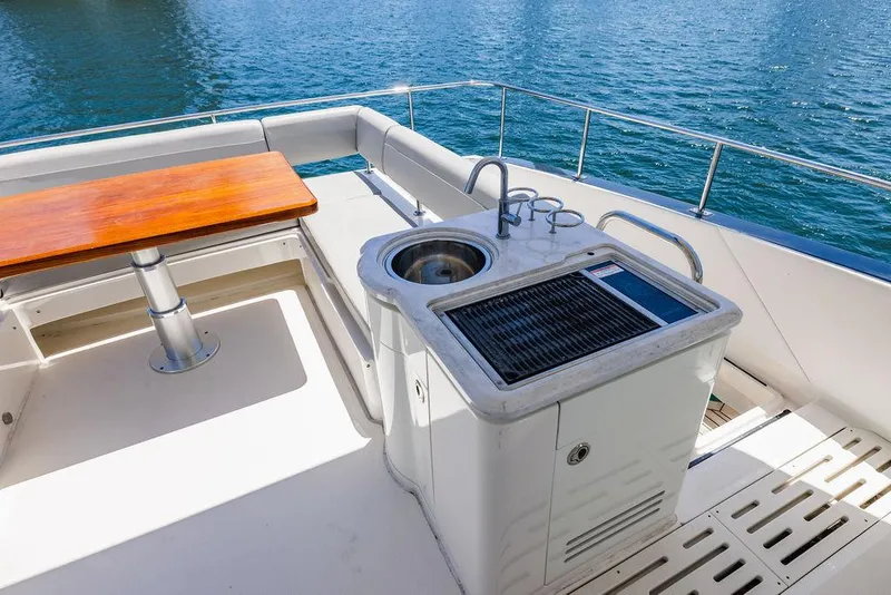 Slide: The Image of 2016 Sea Ray L650 Fly yacht deck with outdoor kitchen and dining area. - 36