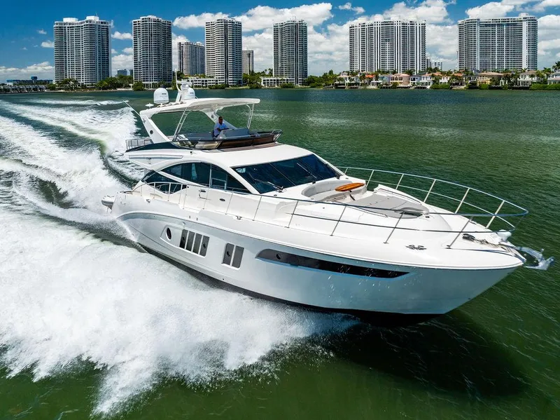 Slide: The Image of 2016 Sea Ray L650 Fly yacht cruising on water with city skyline in background. - 4