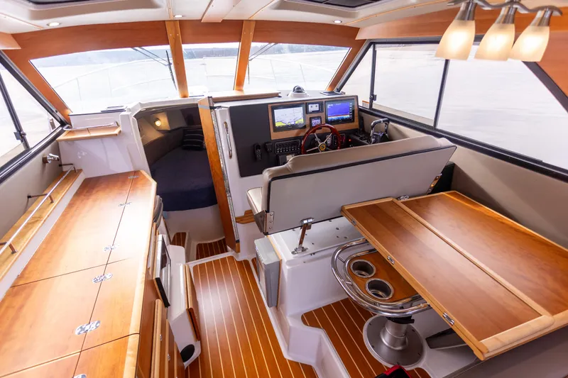 Slide: The Image of Interior of 2021 Cutwater C-32 CB boat with wood finishes and navigation equipment. - 14