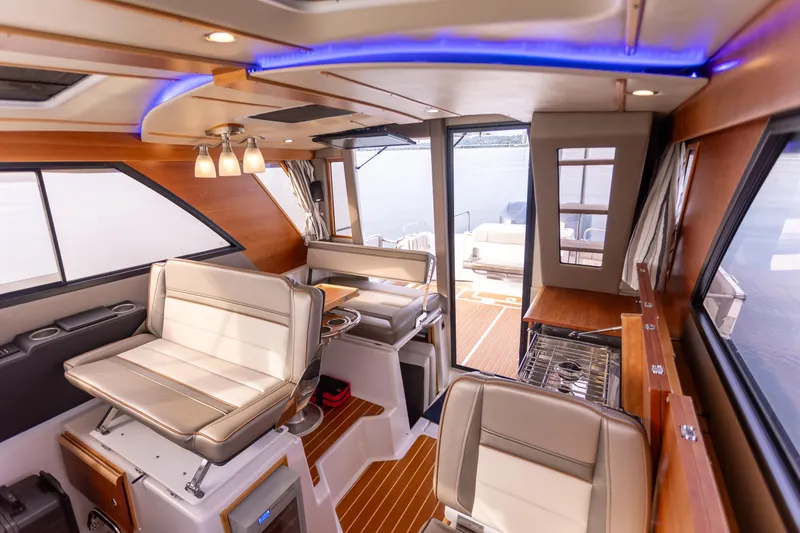 Slide: The Image of Interior of 2021 Cutwater C-32 CB boat, featuring modern seating and wood accents. - 19