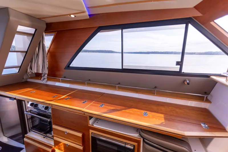Slide: The Image of Interior of 2021 Cutwater C-32 CB yacht with sleek wooden cabinetry and large windows. - 21