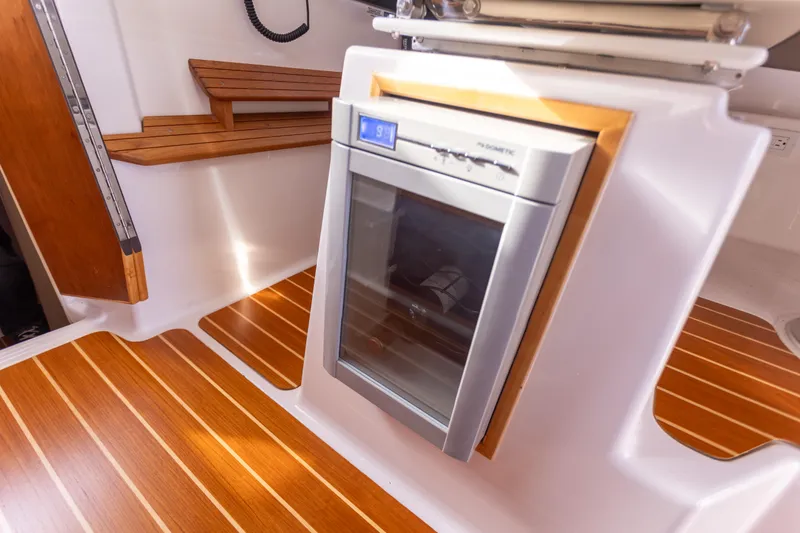 Slide: The Image of 2021 Cutwater C-32 CB interior with wood flooring and built-in refrigerator. - 25