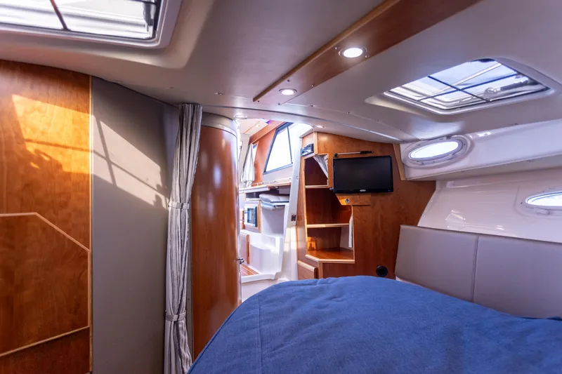 Slide: The Image of Interior of 2021 Cutwater C-32 CB boat, featuring wood paneling and a cozy cabin space. - 29