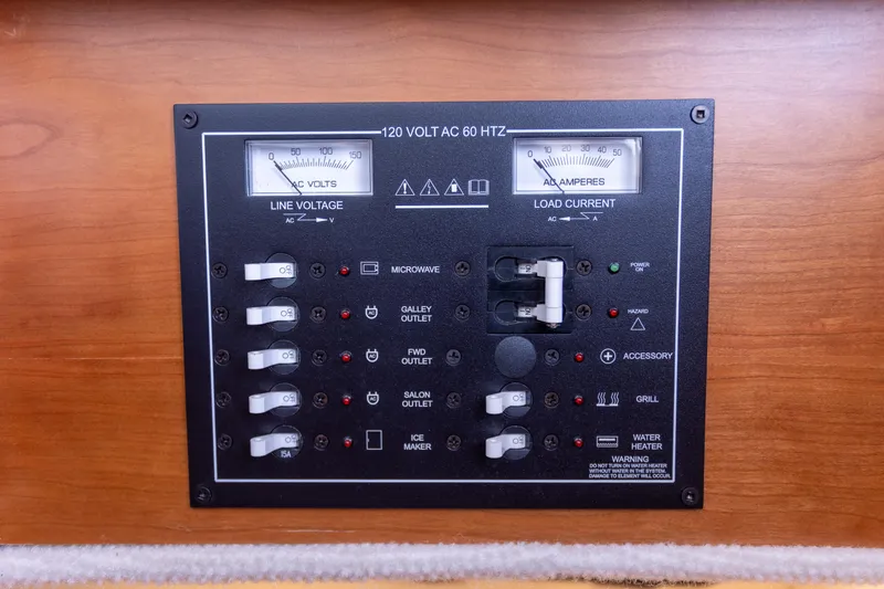 Slide: The Image of Electrical panel on a 2021 Cutwater C-32 CB boat, showing line voltage and load current. - 38