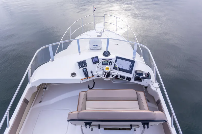 Slide: The Image of 2021 Cutwater C-32 CB boat helm with modern navigation equipment and seating on calm water. - 39