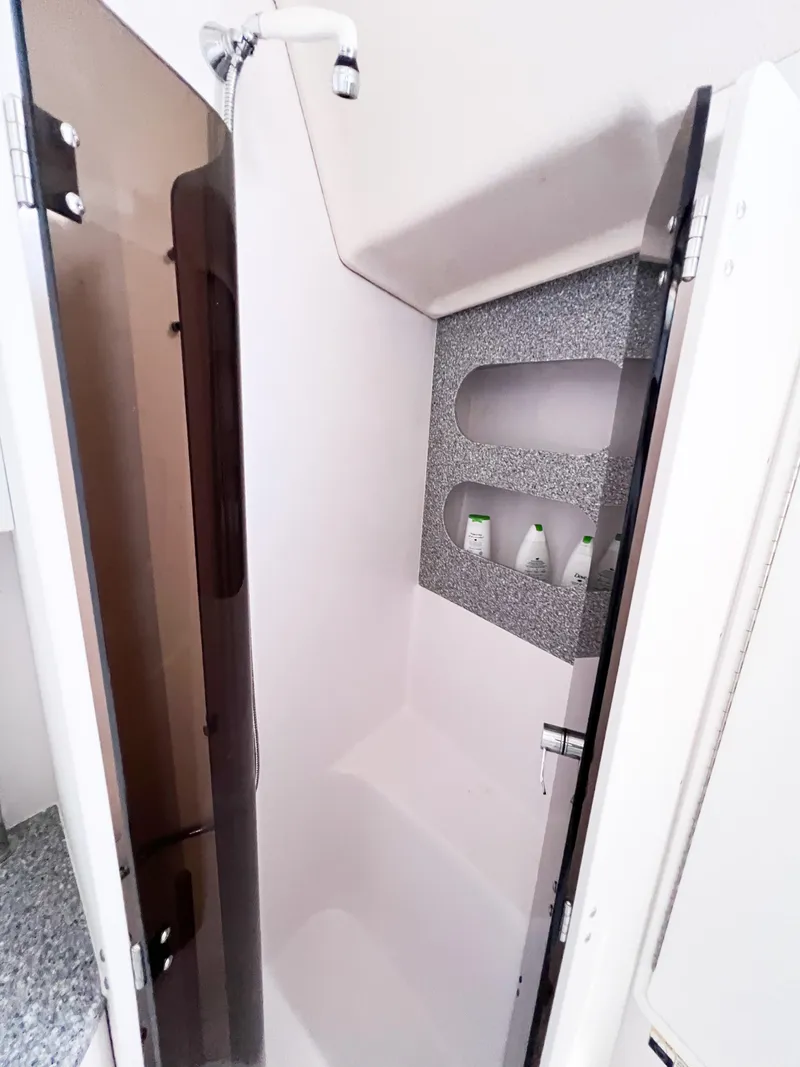 Slide: The Image of Compact shower area in a 2019 Catalina 425 yacht, featuring built-in shelves. - 16