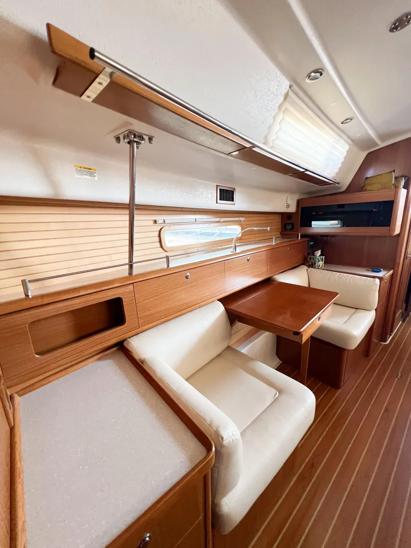 Slide: The Image of 2019 Catalina 425 interior with wooden finish, cozy seating, and dining table. - 19