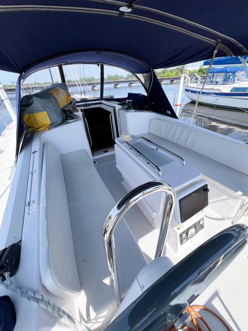 Slide: The Image of 2019 Catalina 425 sailboat cockpit with blue canopy and white seating, docked at marina. - 4