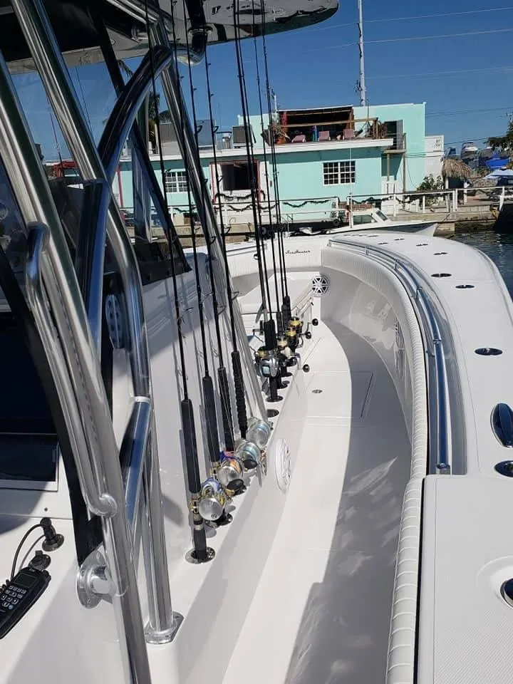 Slide: The Image of 2018 SeaHunter 39 Tournament boat with fishing rods, docked near pastel-colored buildings. - 3