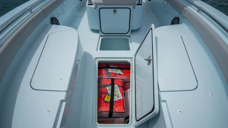 Slide: The Image of 2024 Contender 24 Sport boat with open storage compartments and safety gear. - 12