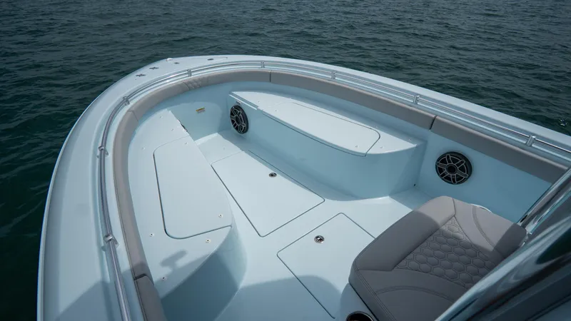 Slide: The Image of 2024 Contender 24 Sport boat interior with seating and storage, on calm water. - 18