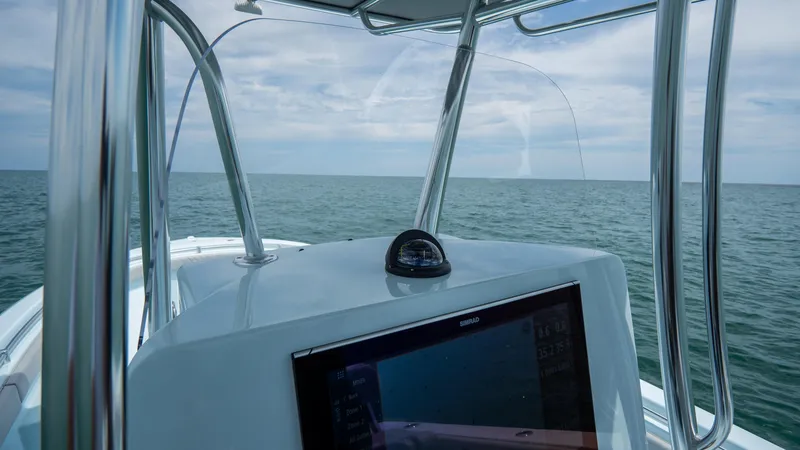 Slide: The Image of 2024 Contender 24 Sport boat dashboard with ocean view and navigation equipment. - 19