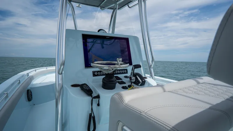 Slide: The Image of 2024 Contender 24 Sport boat console with navigation equipment on open water. - 20