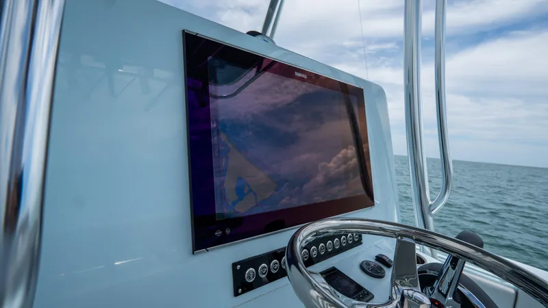 Slide: The Image of 2024 Contender 24 Sport boat dashboard with navigation screen and steering wheel. - 21