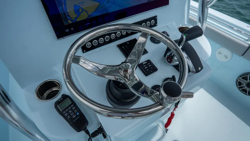 Slide: The Image of 2024 Contender 24 Sport boat dashboard with steering wheel and navigation controls. - 22